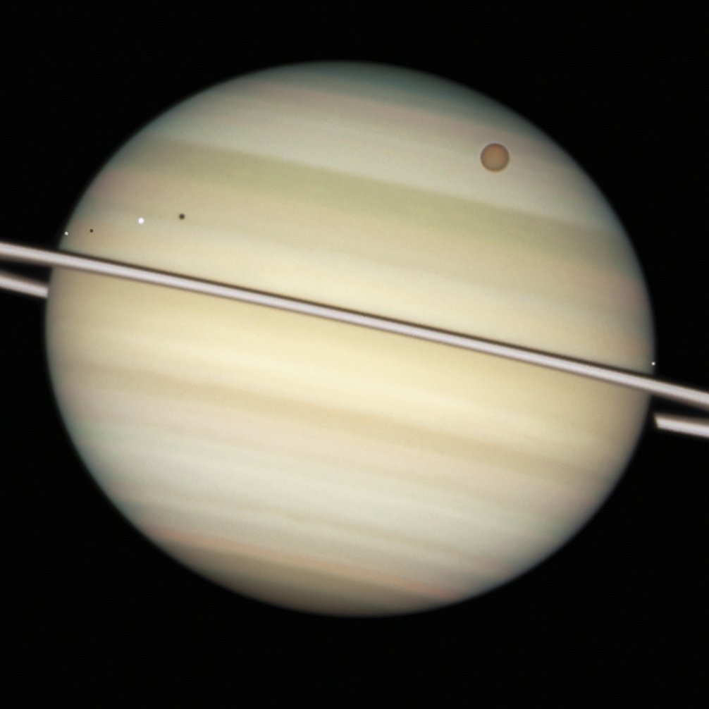 Saturnoren lau ilargiren iragatea, eta haietako biren itzalak